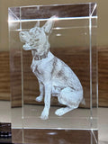 Crystal block with engraved dog design on a surface

